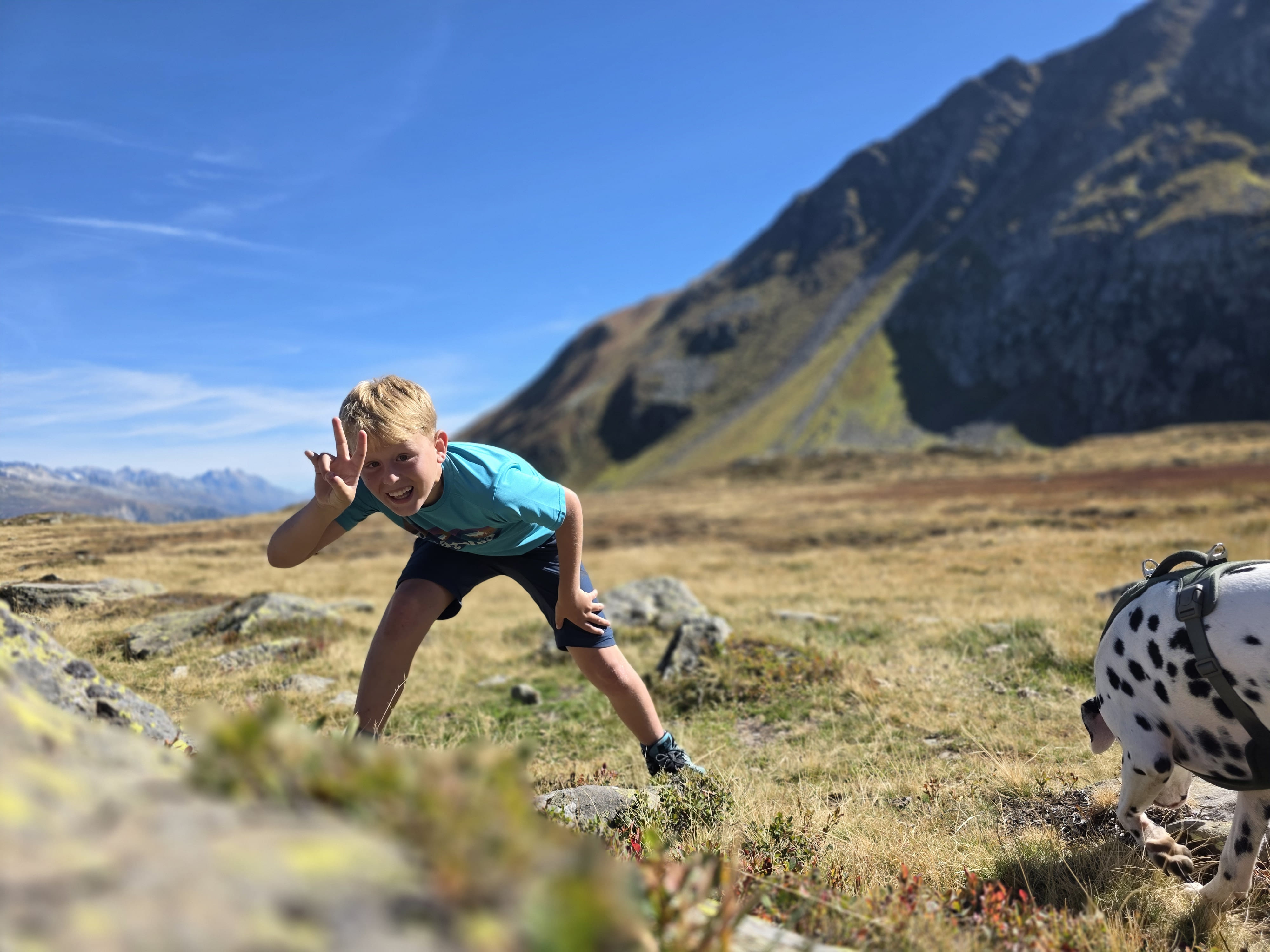 Yuri winkt beim Wandern in den Bergen in die Kamera